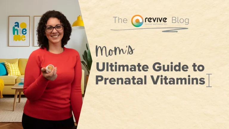 A smiling woman with curly dark hair, wearing glasses and a red sweater, holds out a small container of prenatal vitamins in a cozy living room with colorful pillows and framed artwork on the wall. On the right side, a beige background displays the text 'Mom’s Ultimate Guide to Prenatal Vitamins' with 'The Revive Blog' logo above it.